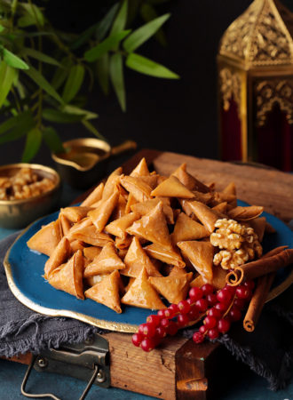These sweet 'lil treats will make everyone go nuts! Bite-size crispy samosa triangles filled with an aromatic mixture of walnuts and cinnamon, and sweetened  with drizzles of spiced sugar syrup. Good luck stopping at one!