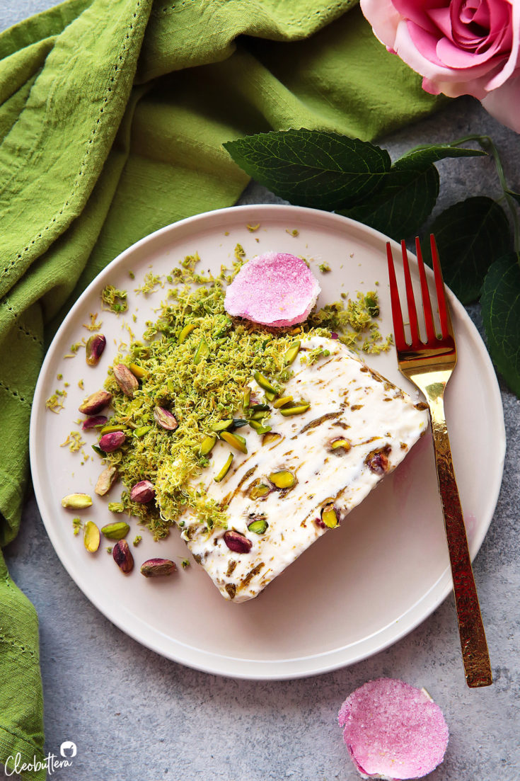 A show stopping ice cream cake with the much-loved flavors of the Middle East!  Scented eshta no-churn ice cream with nibs of caramelized pistachios, swirls of pistachio butter and a crown of green pistachio kunafa on top.  It is a pistachio lover dream come true and much easier to make than it seems.  Plus...recipe VIDEO at the end of the post!