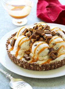 This easy ice cream pie is bursting with KitKat in every bite! Vanilla ice cream with crispy chunks of KitKat and swirls of salted caramel, sit atop a pie crust made from crushed KitKat bars.  Delicious!