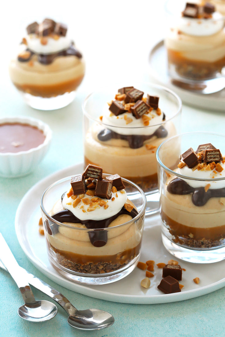  These delightful cups of decadence, feature a bottom base of crushed KitKat and roasted peanuts, salted caramel sauce, a cloud-like peanut butter filling, all topped off with a chocolate ganache sauce, whipped cream and chunks of KitKat and peanut bits.  VIDEO recipe at the end of the post!
